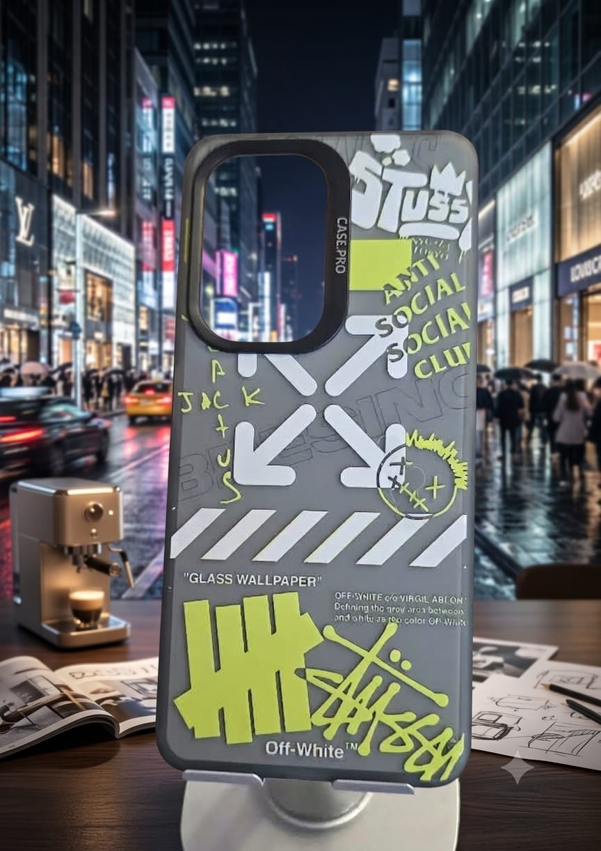 A gray Off-White phone case with graffiti-style graphics and text, displayed on a stand in front of a blurred Times Square city night scene.